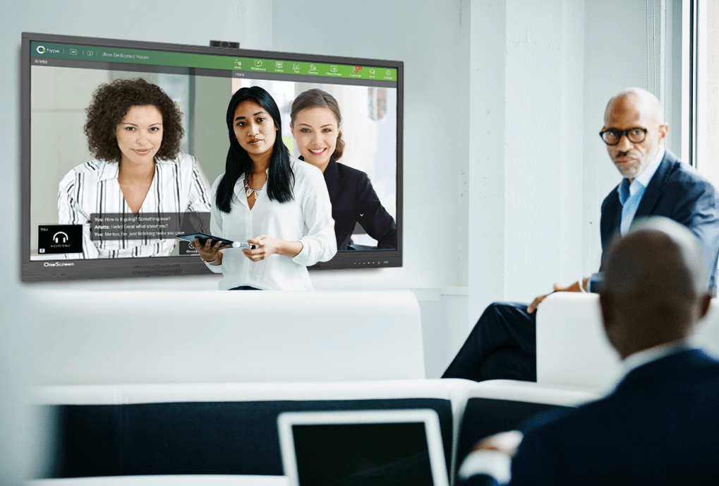 Coworkers in meeting room using video chat on TV